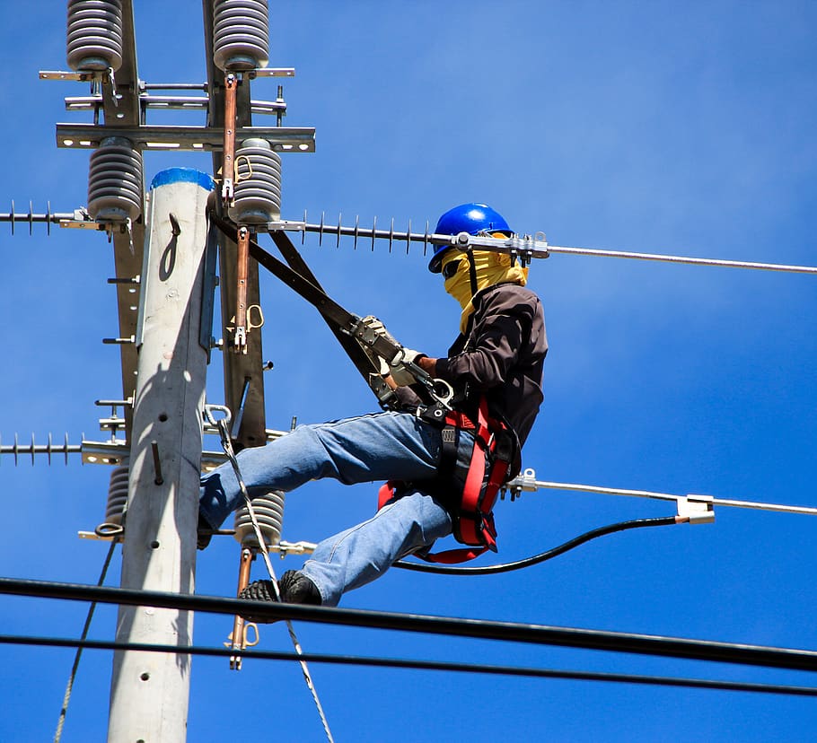 selective-photography-of-electrician-on-electric-pole-during-daytime